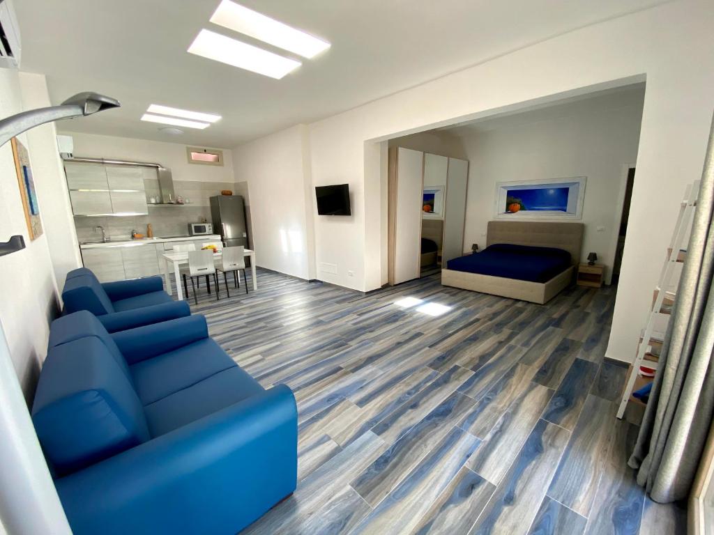 sala de estar con sofá azul y dormitorio en Appartamenti Acquazzurra en Portoferraio