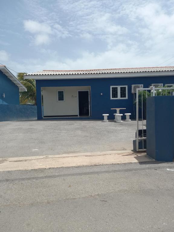 a blue and white building with a parking lot at Blue Apartments in Willemstad