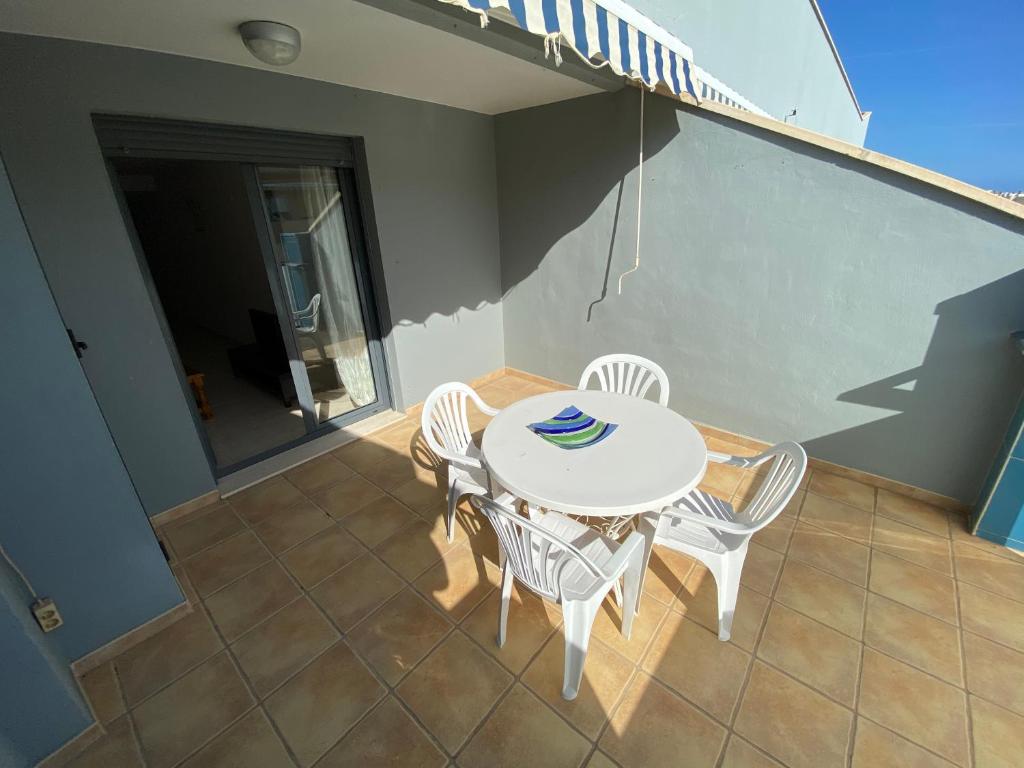 a table and chairs on the balcony of a house at Apartamentos Sotavento Altamar in Alcossebre