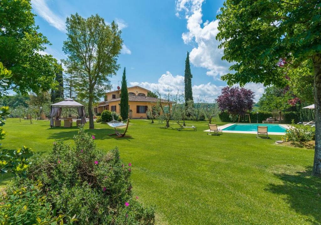 un patio con una casa y una piscina en Santa Margherita Vacanze, en Poggibonsi