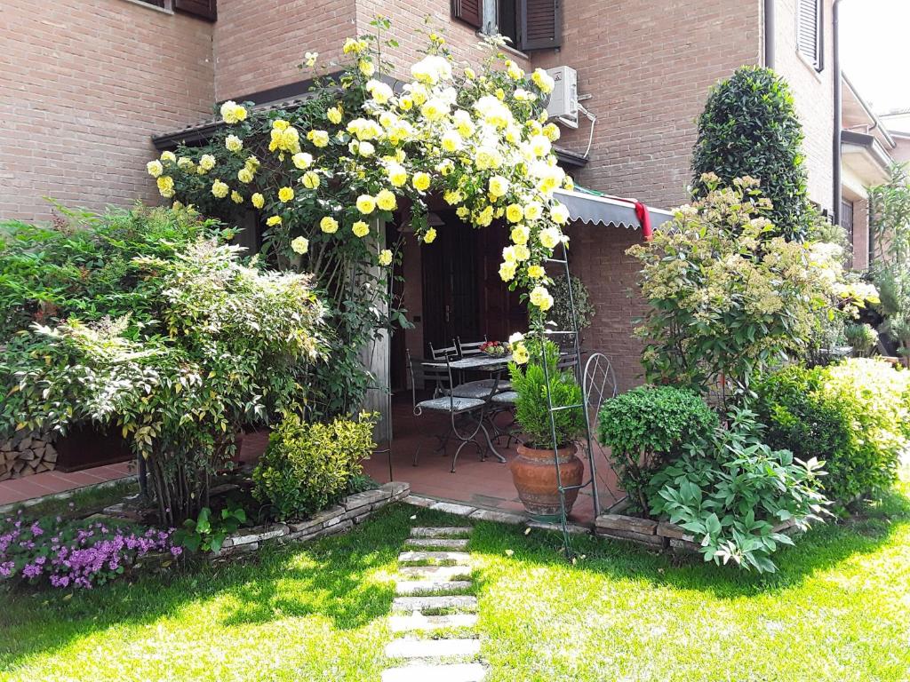einen Garten mit einem Blumenstrauß vor einem Gebäude in der Unterkunft B&B LA ROSA GIALLA in Maranello