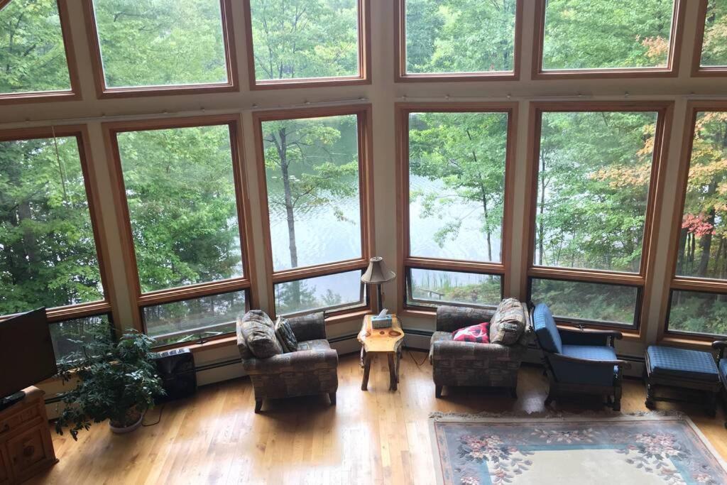 a large room with large windows with couches and a table at Amy’s lake house in Traverse City