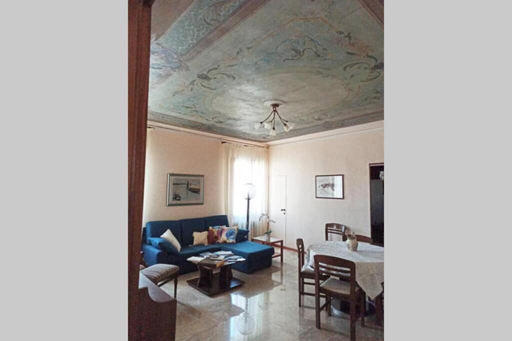 een woonkamer met een blauwe bank en een tafel bij Palazzo Baffo - Residenza storica , Chioggia in Chioggia