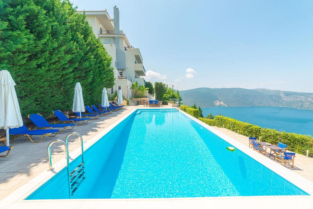 een zwembad naast een hotel met uitzicht op het water bij Skroponeria View Apartments in Skroponeria