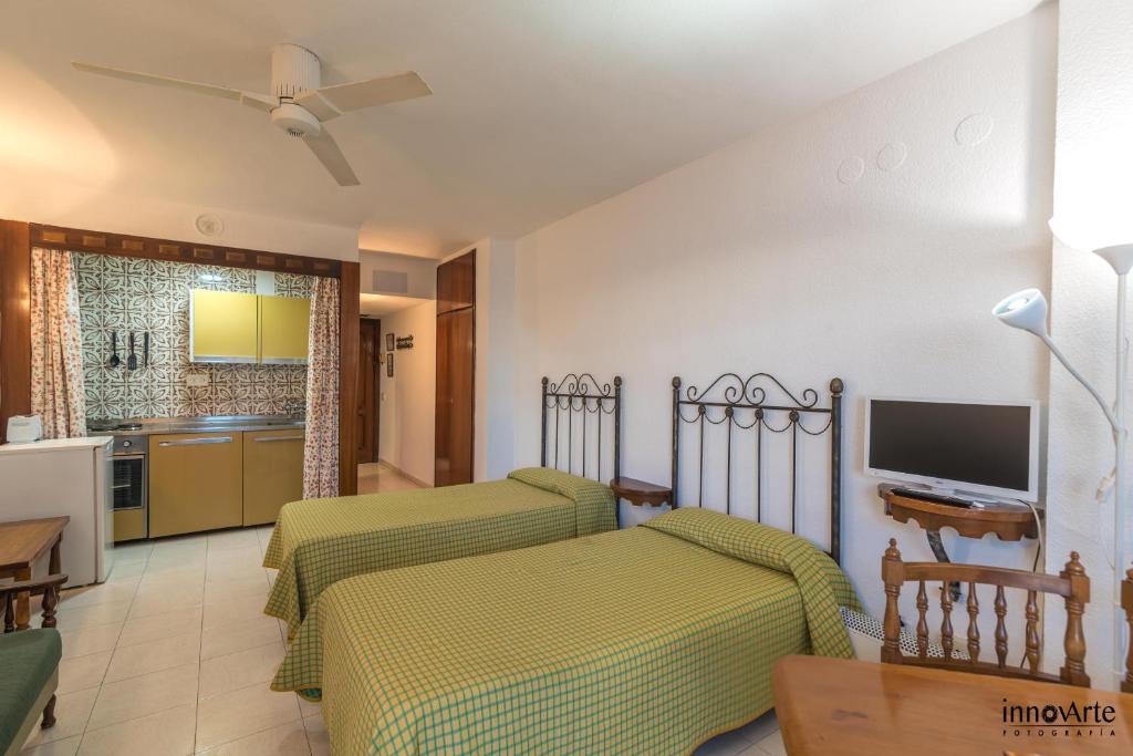 1 Schlafzimmer mit 2 Betten und einer Küche in der Unterkunft APARTAMENTOS CHINASOL (OFERTAS) in Almuñécar