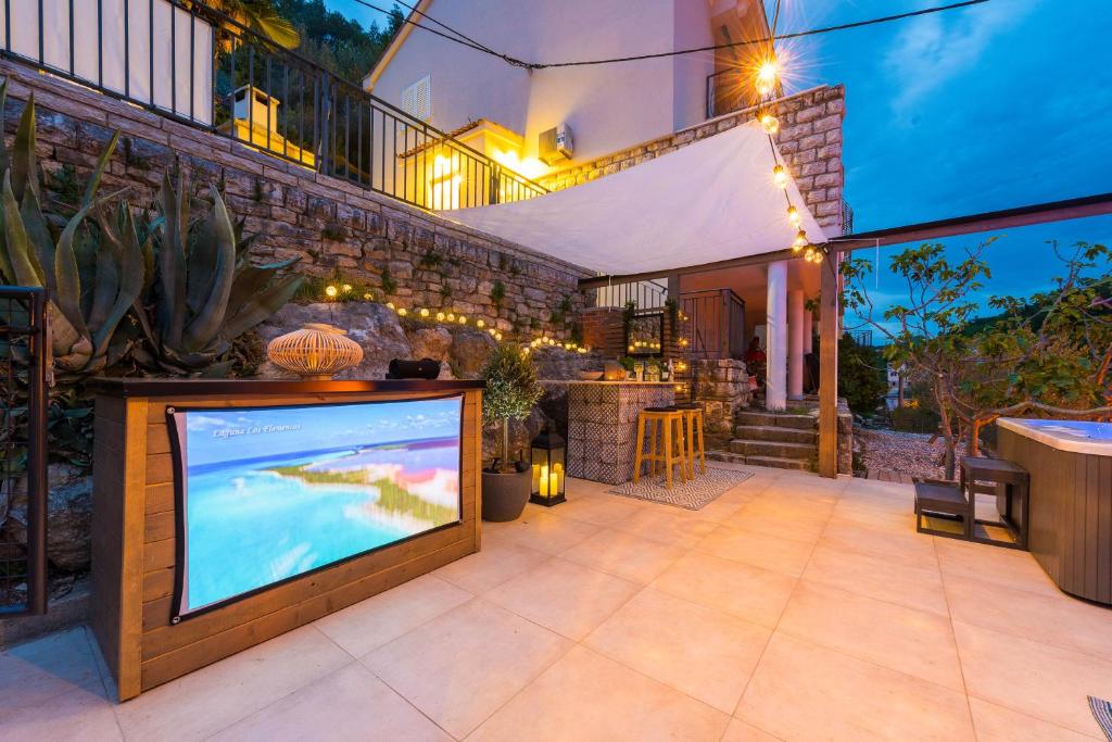 an outdoor patio with a television and a bar at Villa Calendula in Novigrad Dalmatia