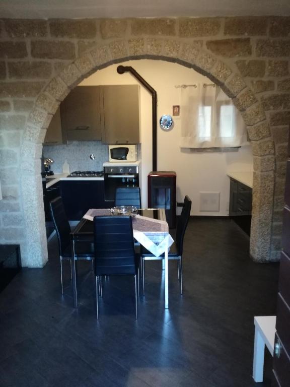a kitchen and dining room with a table and chairs at Monti di bò in Aggius