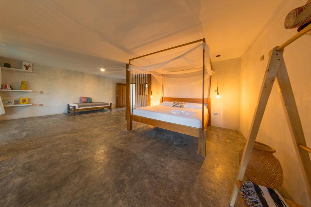 a bedroom with a canopy bed in a tent at Casa Chapolin Boutique Guesthouse in Palomino