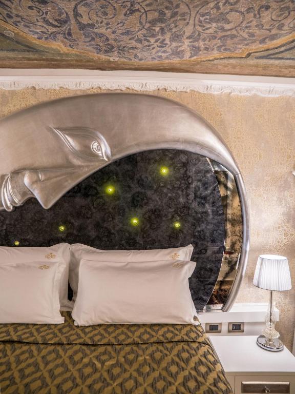 sypialnia z łóżkiem z zagłówkiem delfina w obiekcie EGO' Boutique Hotel - The Silk Road w Wenecji
