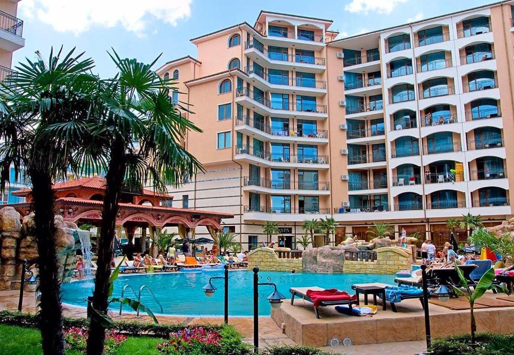 een resort met een zwembad en een groot gebouw bij Karolina Hotel in Sunny Beach