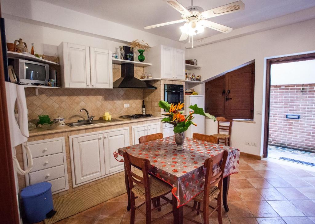 eine Küche mit einem Tisch und einer Blumenvase darauf in der Unterkunft Erasippe Residence in Locri