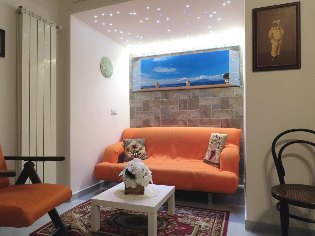 Casa Louga في سورينتو: غرفة معيشة مع أريكة برتقالية وطاولة