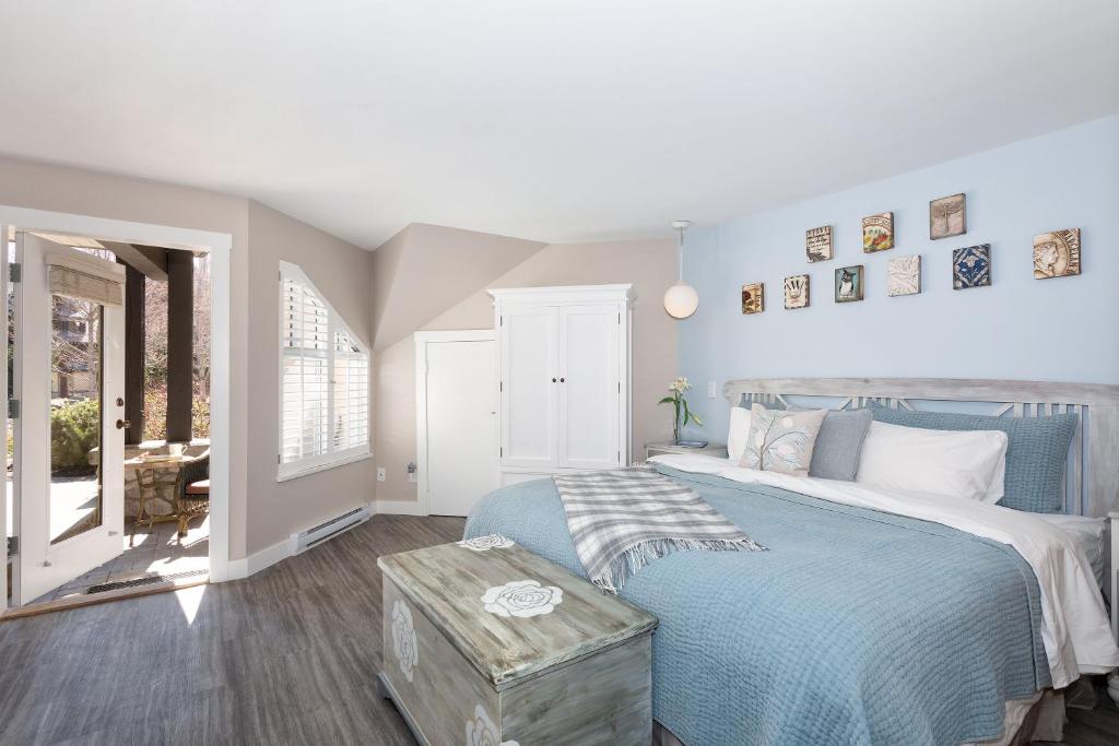 une chambre avec un lit bleu et une fenêtre dans l'établissement Renovated & Spacious 1bed/2bath Whistler Village, à Whistler