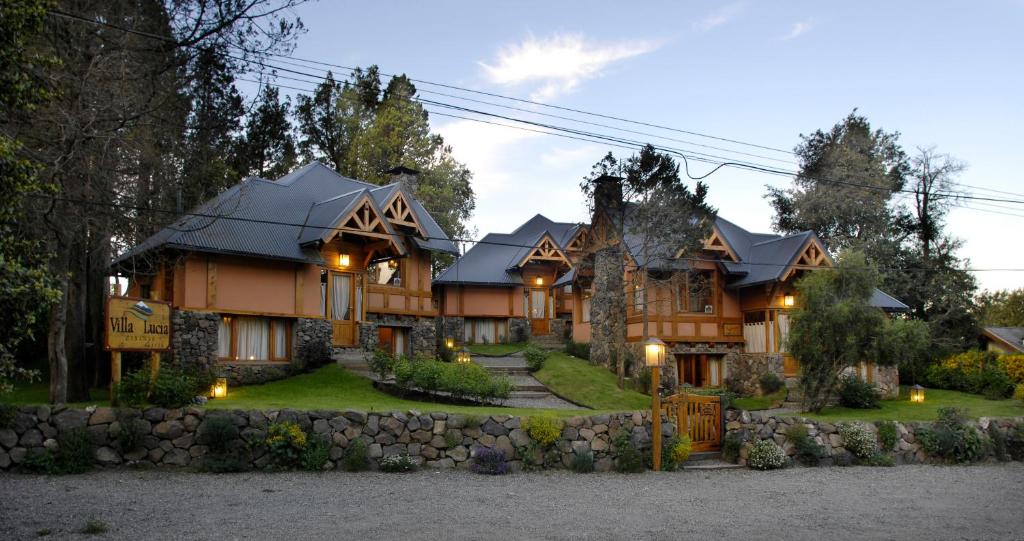 a large house with a stone wall at CABAÑAS VILLA LUCIA "UNº1 Virreyna" in San Carlos de Bariloche