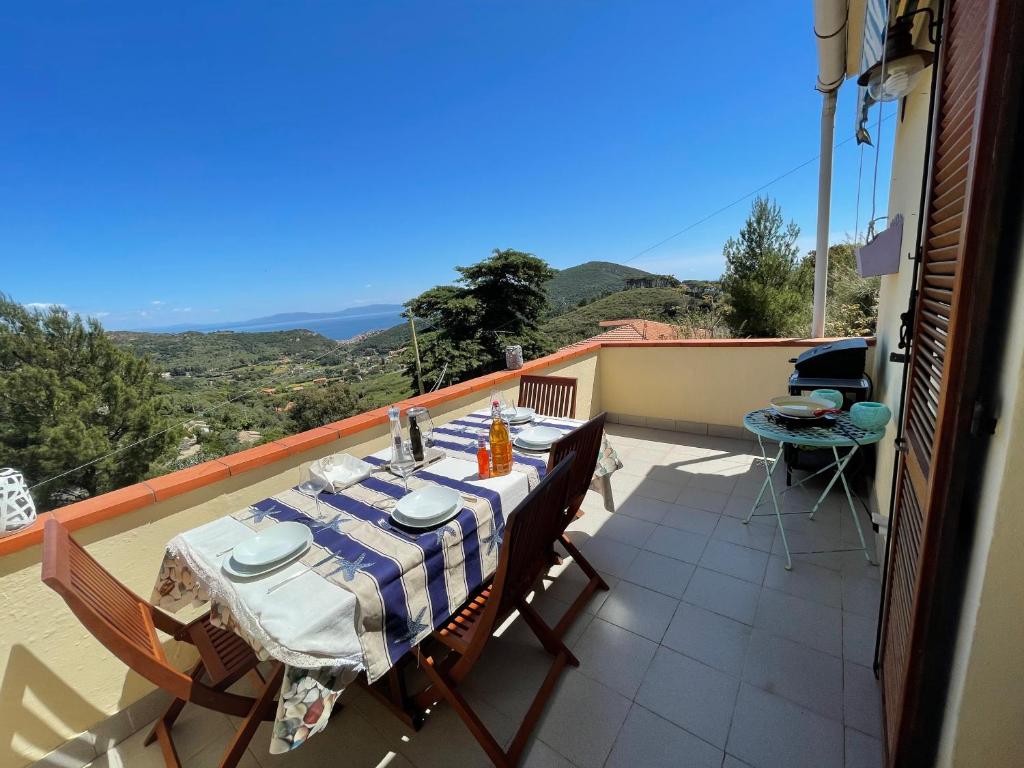 einen Tisch und Stühle auf einem Balkon mit Aussicht in der Unterkunft VerdeMare in Rio nellʼElba