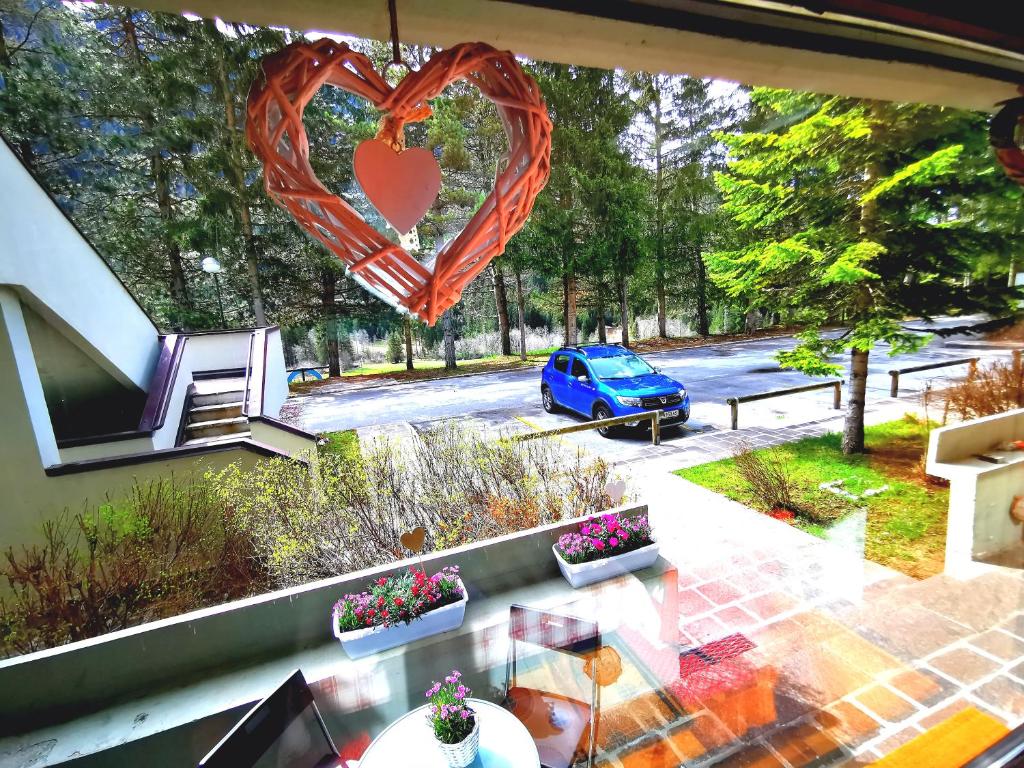 un corazón colgando de la ventana de una casa en DaPolo - Cosy appartment in Val di Fassa, en Campestrin