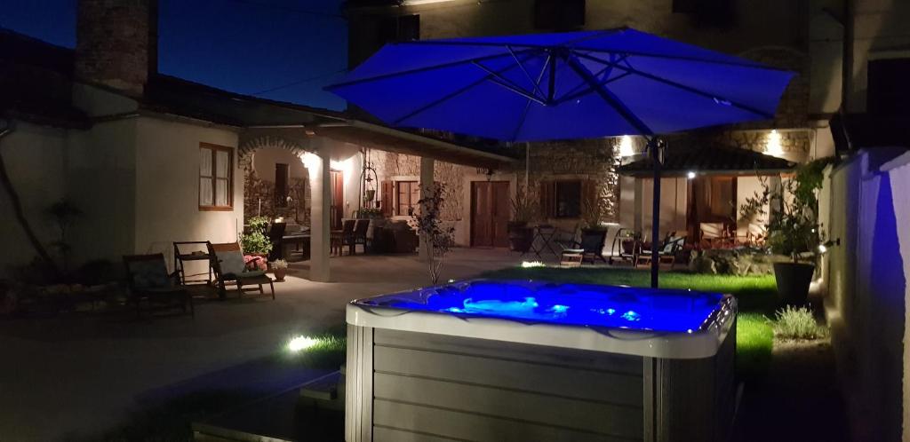 a hot tub with blue lights in a yard at night at Rooms & Apartment STELIO in Loborika