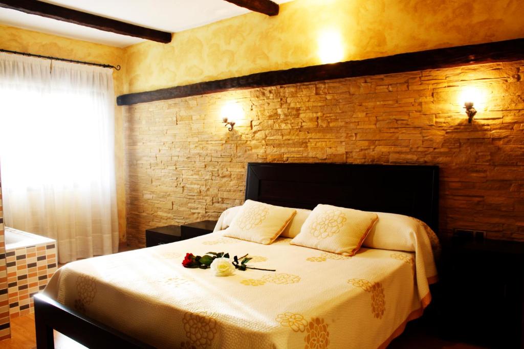 Un dormitorio con una cama con flores. en Hostal El 402 en Iznalloz