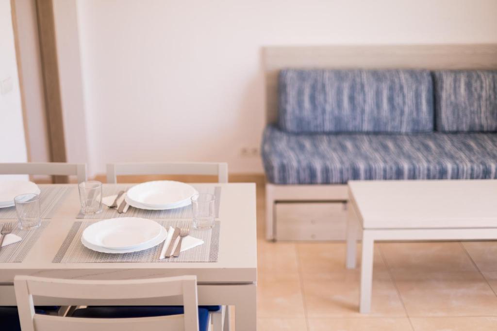 a living room with a table, chairs and a coffee table at Apartamentos Avenida - MC Apartamentos Ibiza in Ibiza Town