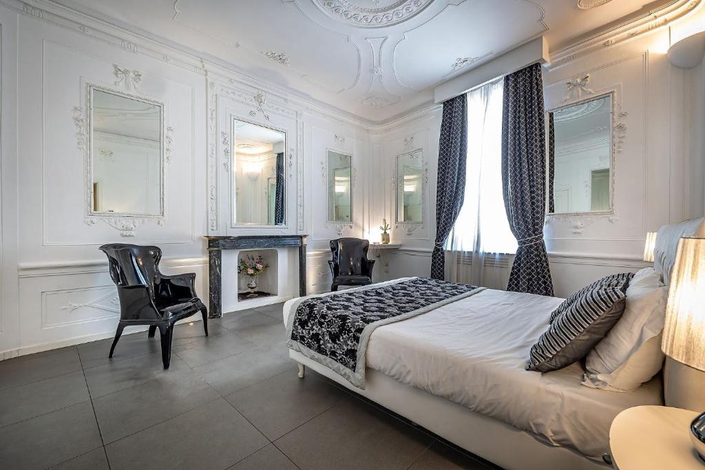 ein Schlafzimmer mit einem Bett und Stühlen sowie einem Kamin in der Unterkunft Boutique Hotel La Casa di Morfeo in Florenz