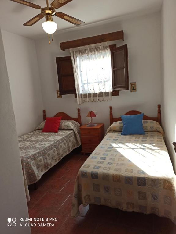 een slaapkamer met twee bedden en een raam bij Casa cecilio in Nerja