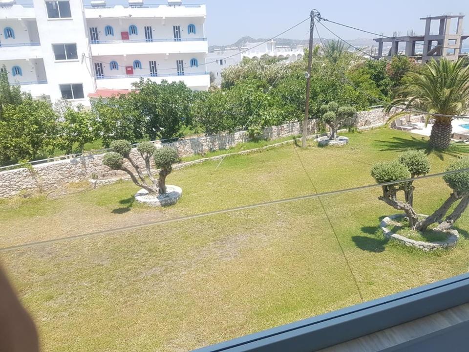 a view from a window of a yard with trees at Lilly Apartment in Faliraki