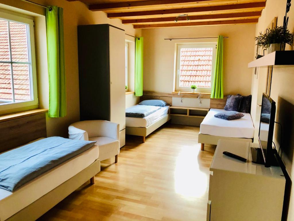 Zimmer mit 2 Betten, einem TV und 2 Fenstern in der Unterkunft Scheilhof in Hirschbach