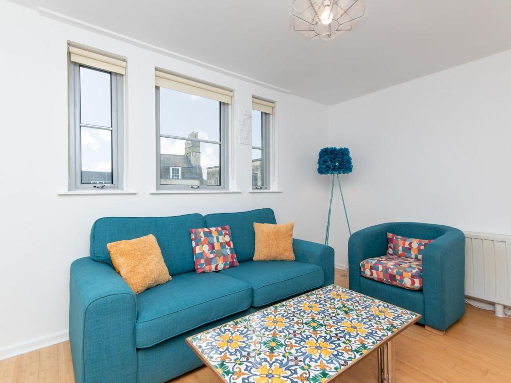 ein blaues Sofa und einen Couchtisch im Wohnzimmer in der Unterkunft Pass the Keys Bright modern one bed apartment - Bath city centre in Bath