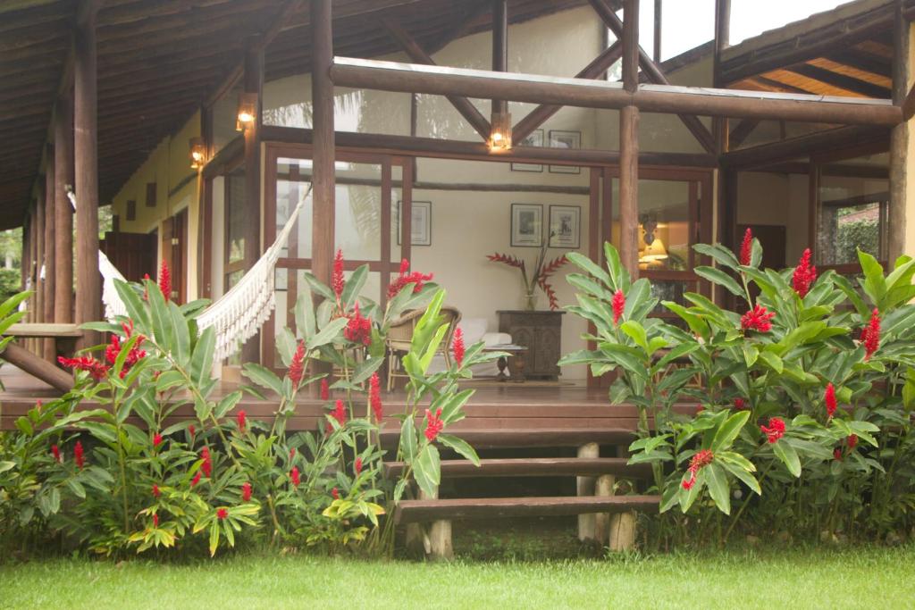 una casa con un montón de plantas y flores rojas en Casa Bon Voyage Caboré - Chez Cira, en Paraty