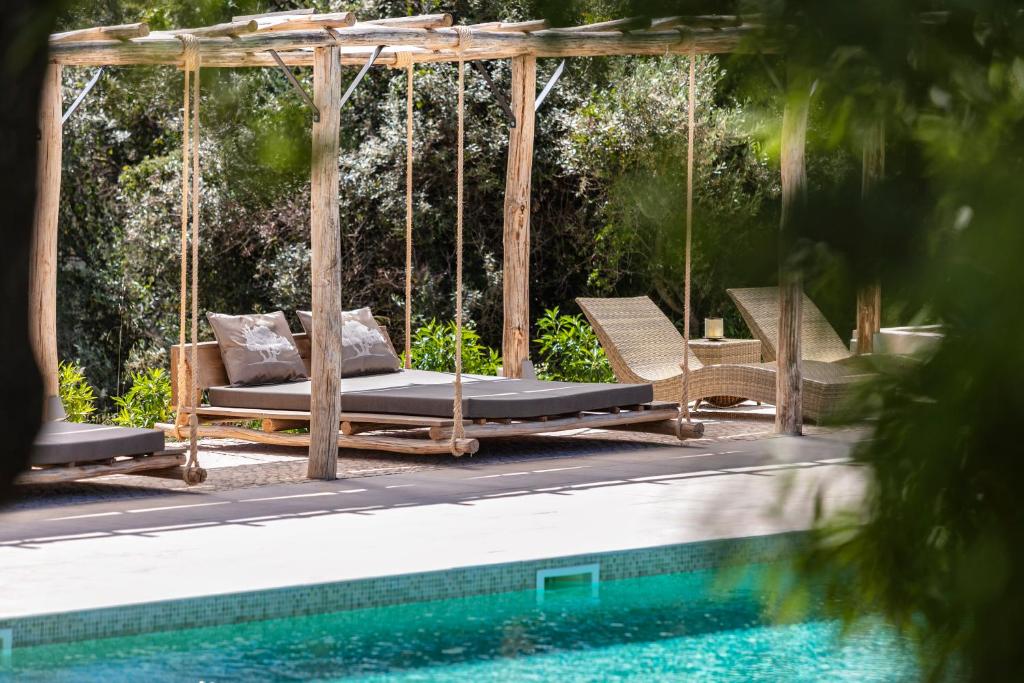 a swing with a bed next to a swimming pool at Casa Tuia Resort in Carvoeiro