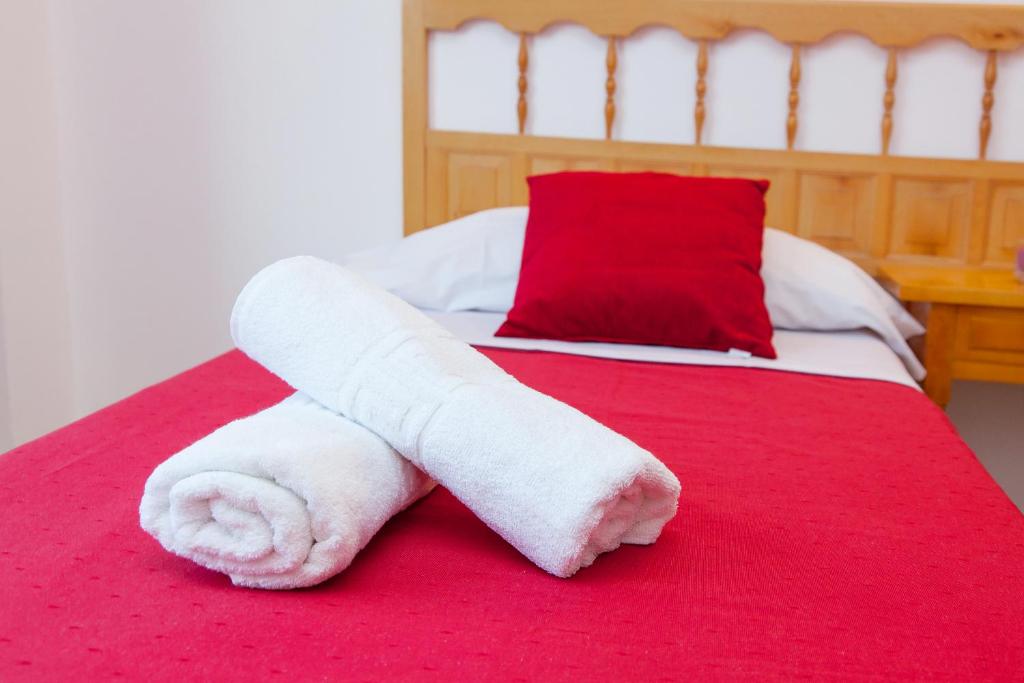 a towel on a bed with a red blanket at Apartamentos Puet in San Antonio