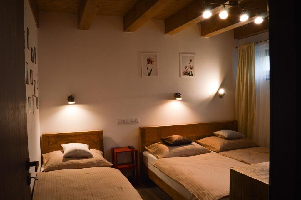 sypialnia z 2 łóżkami i lampkami na ścianie w obiekcie Apartmány Okrouhlá w mieście Nový Bor