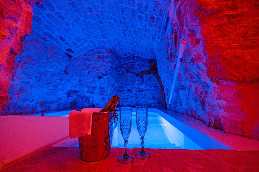 bañera en una habitación con luces rojas y azules en Petra Suite en Alberobello