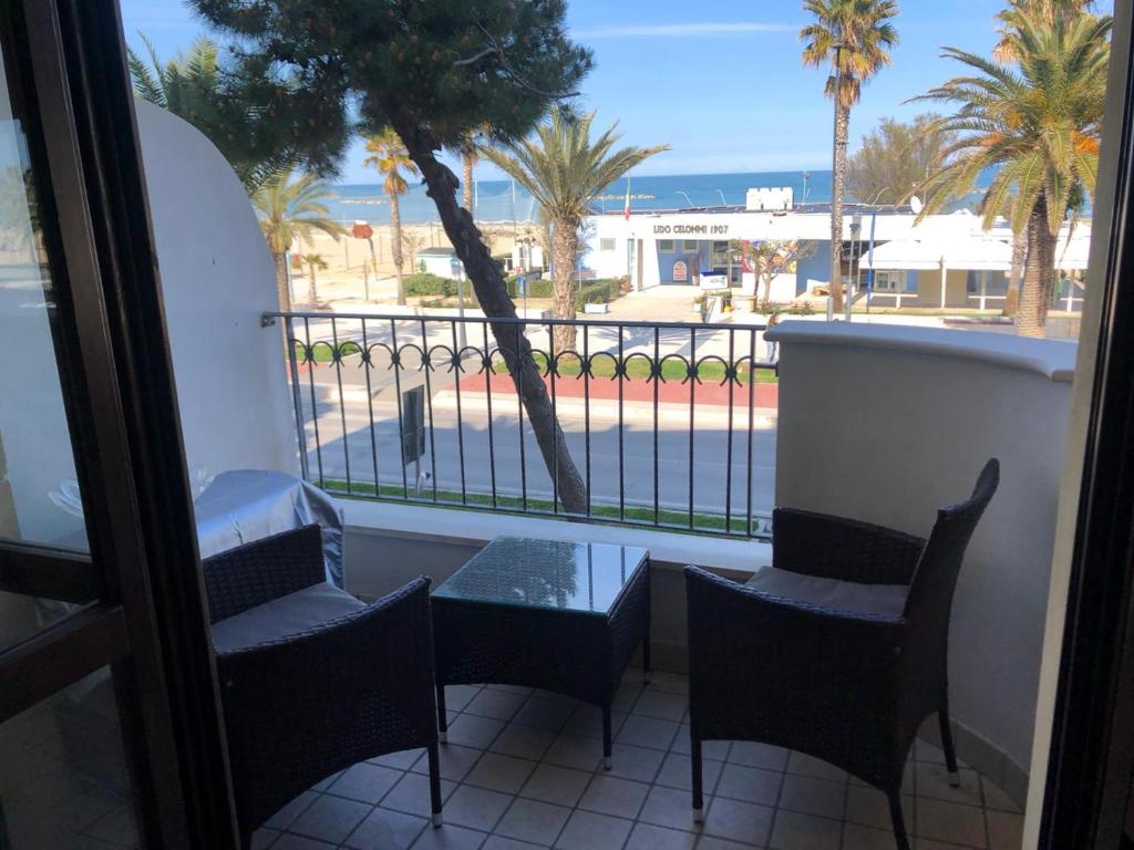 a balcony with chairs and a table and a view of the ocean at Pini sul Mare in Roseto degli Abruzzi
