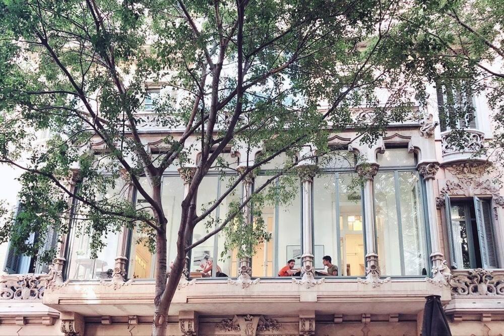 a white building with people sitting in a window at Cami Gallery Barcelona in Barcelona