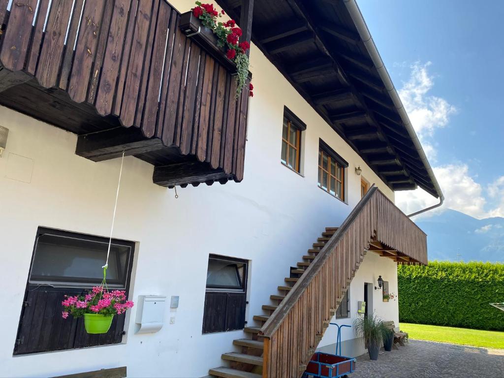 una casa con una escalera y flores en la ventana en VIII Panorama-Ferienwohnung Petzenblick, en Sankt Michael ob Bleiburg