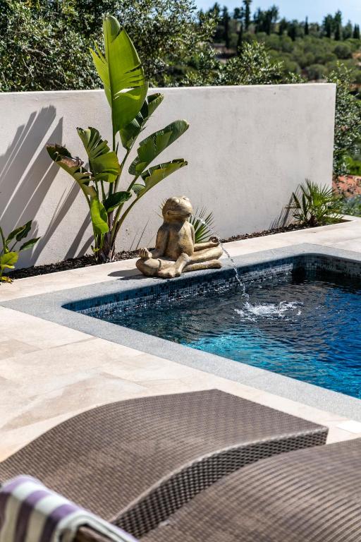 a teddy bear sitting next to a swimming pool at Casa Tuia Resort in Carvoeiro