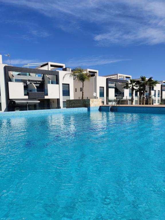 uma grande piscina em frente a uma casa em OASIS BEACH apartments em Alicante