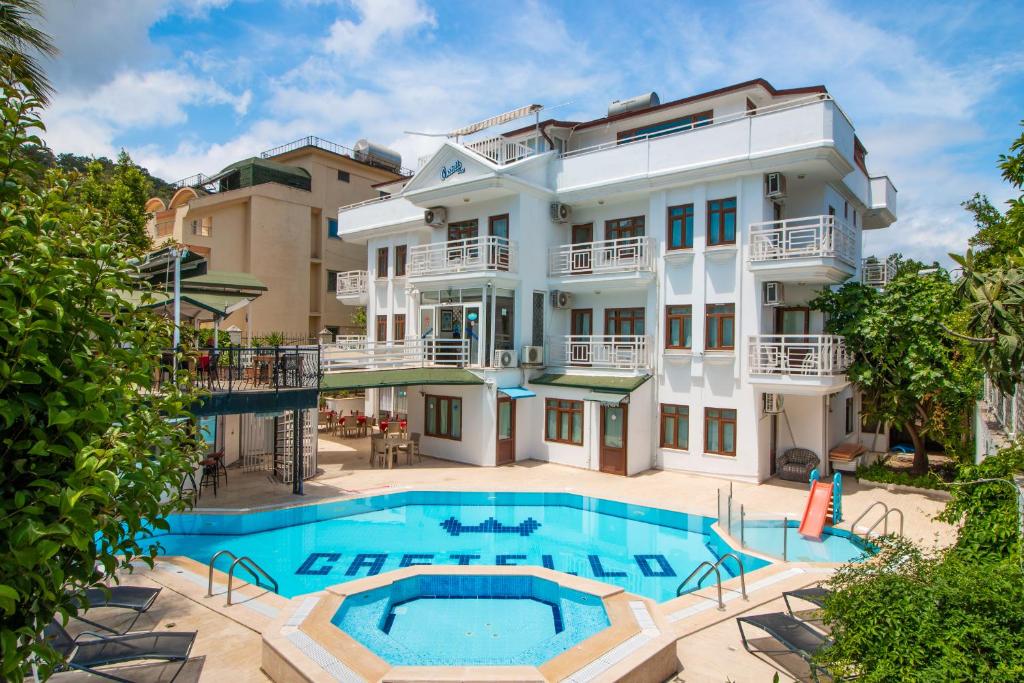 an exterior view of a building with a swimming pool at Castello Hotel & Aparts in Kemer