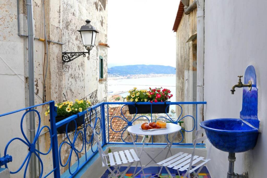 a blue balcony with a table and a bowl of fruit at Il Nido di Raito in Vietri sul Mare