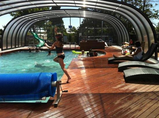 a woman jumping into a pool in a swimming pool at All Seasons Holiday Park in Rotorua