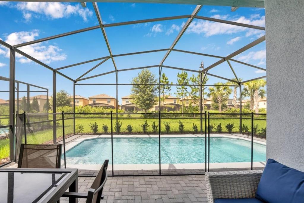 - une vue sur la piscine depuis une maison en verre dans l'établissement Solterra Resort Great For Families Near Disney! villa, à Davenport