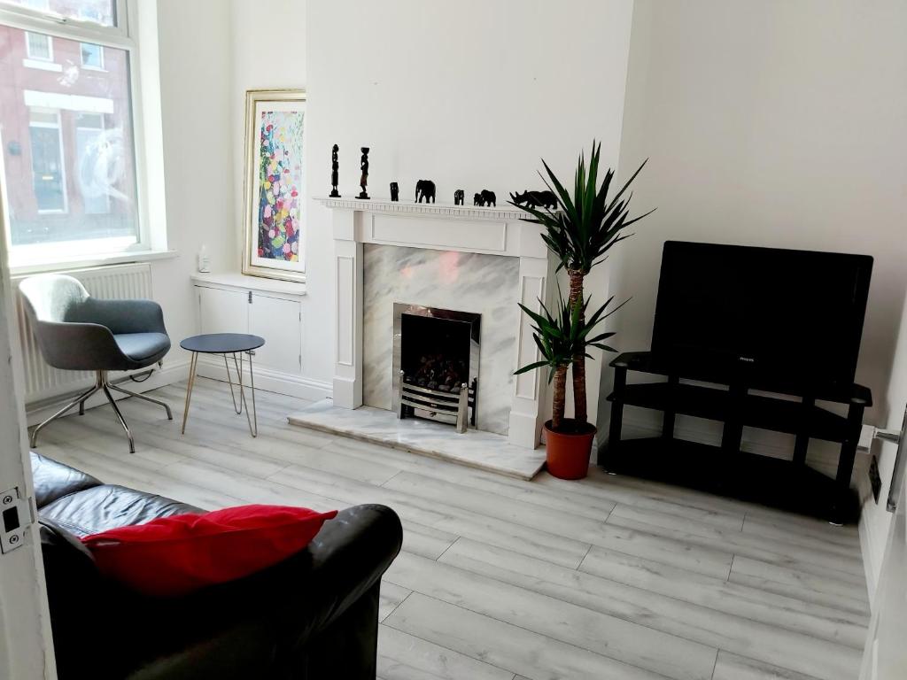 sala de estar con chimenea y TV en Gorgeous Stylish Cheri Victorian House In Manchester, en Mánchester