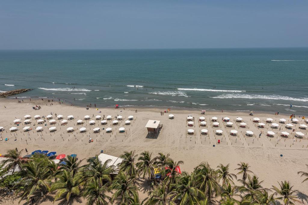 a beach filled with lots of beach chairs and umbrellas at Hotel Regatta Cartagena in Cartagena de Indias