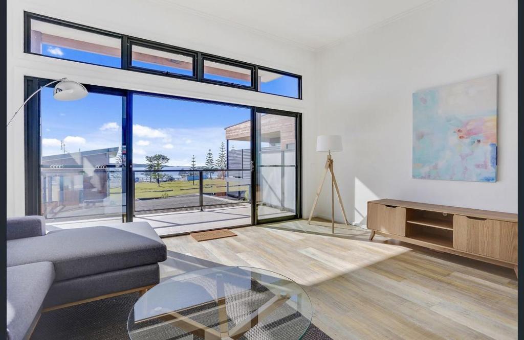 a living room with a couch and a large window at The Shore Break Eden in Eden