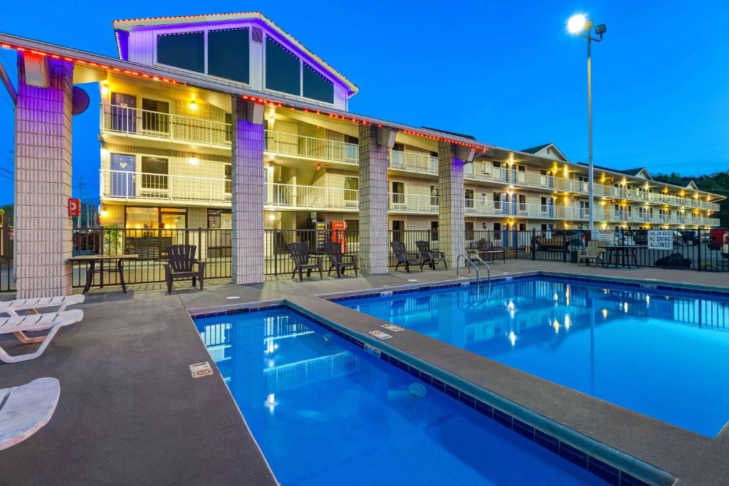 a pool in front of a hotel at night at Briarstone Inn in Pigeon Forge