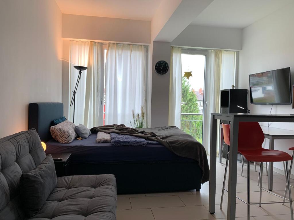 Dormitorio con cama, escritorio y TV en Exklusive Wohlfühloase by Rabe - Parkplatz & free Netflix & Coffee-Bar en Karlsruhe