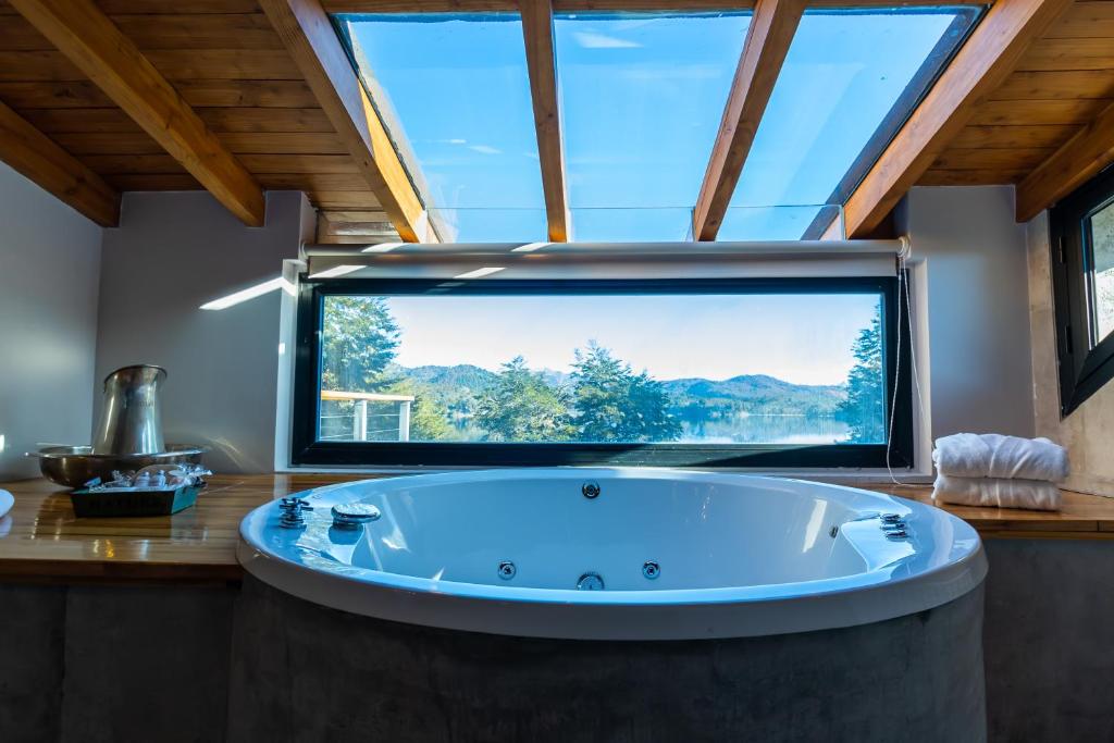 a large tub in a room with a large window at Amarras in Villa Pehuenia