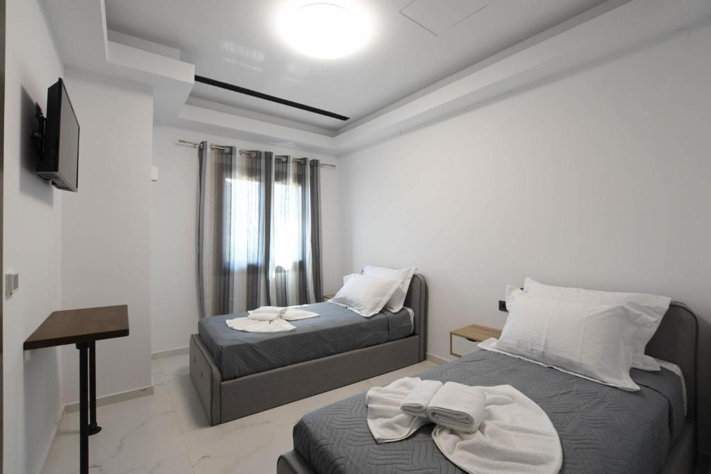 a bedroom with two beds and a table in it at Orion Eco Suites in Karteros