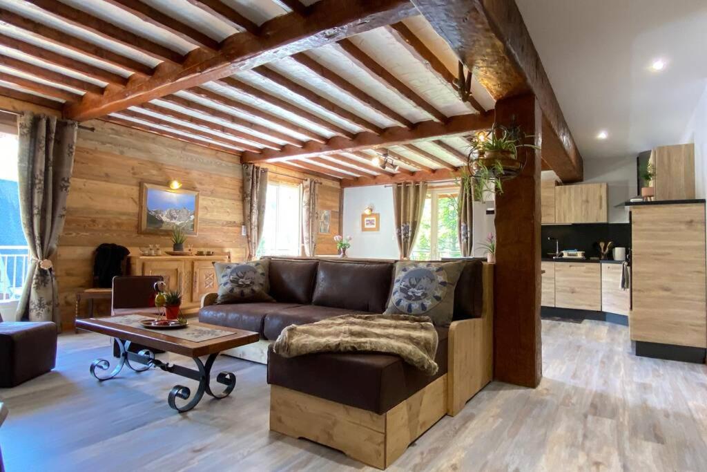 un salon avec un canapé et une table dans l'établissement Vaste T4 115m2. Balcon. Vue. Suite. Jardin et jeux, à Cauterets